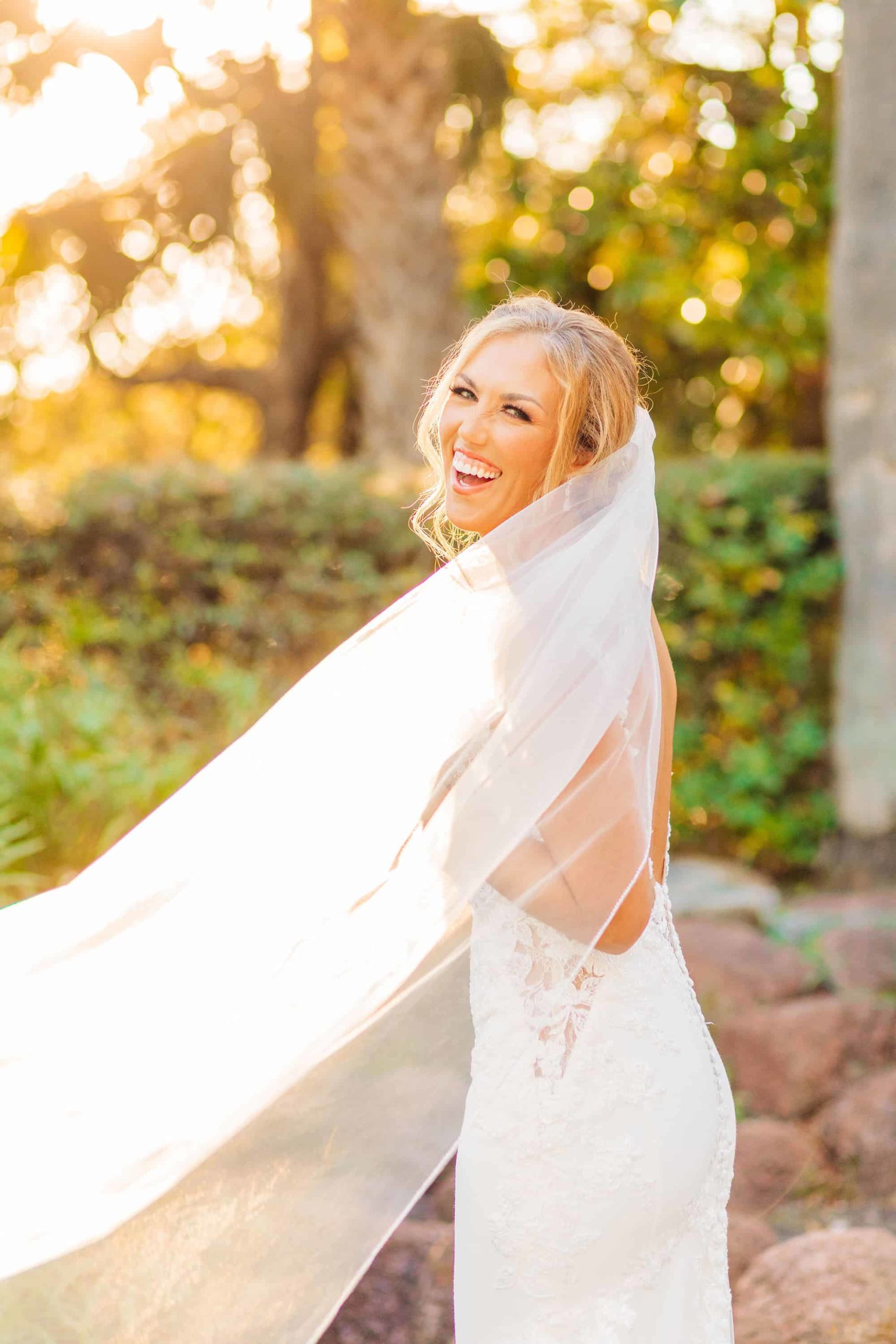 Bride laughing at the camera behind her veil by Indy Pop Photo