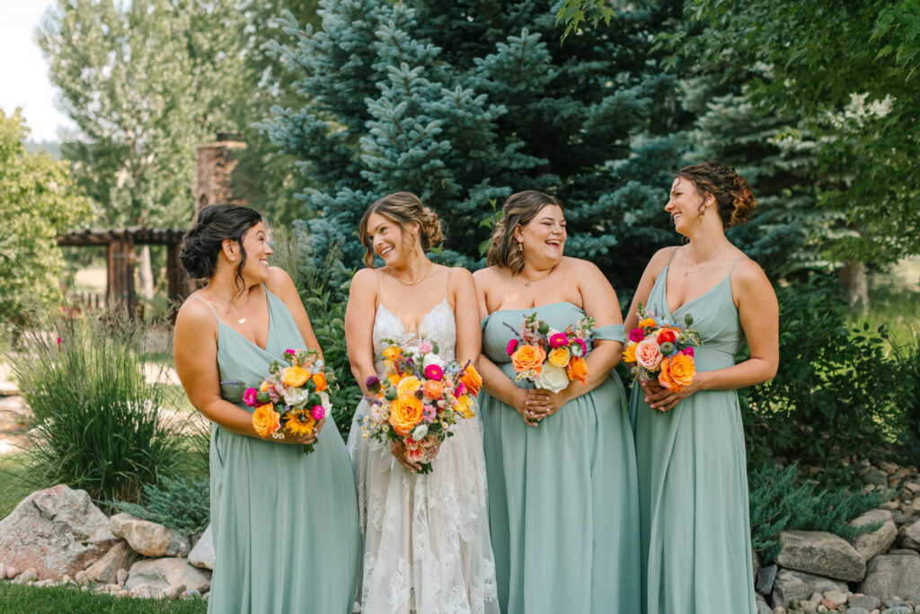 Bride smiling with her bridesmaids at spruce mountain ranch