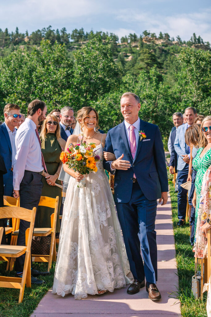 Bride walking down the aisle with her father at spruce mountain ranch