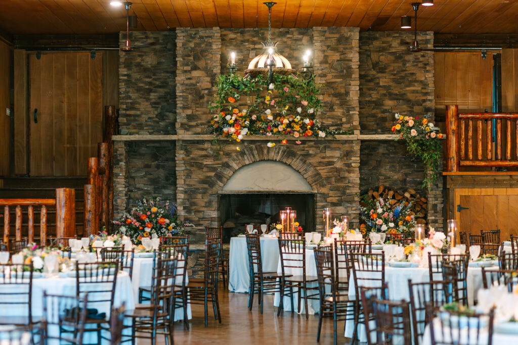 Bright and colorful sweetheart table and floral chandelier at reception by Lil Bug Floral