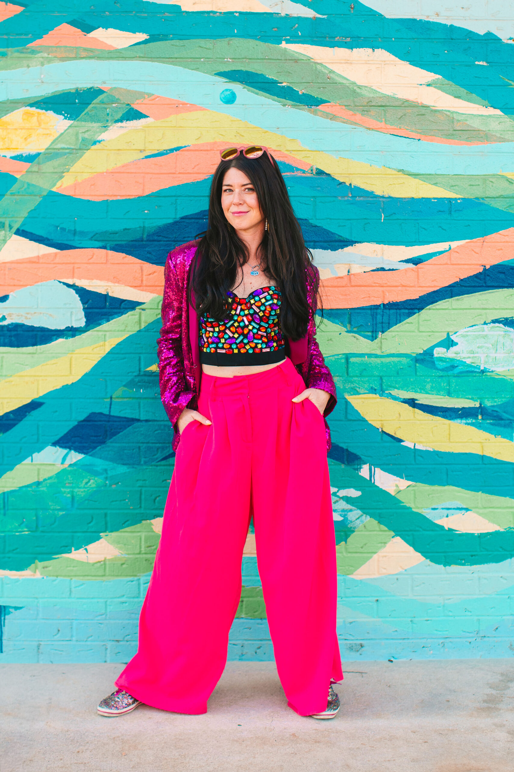 Colorful personal branding photoshoot outfit featuring a pink sequin jacket against a vibrant mural background