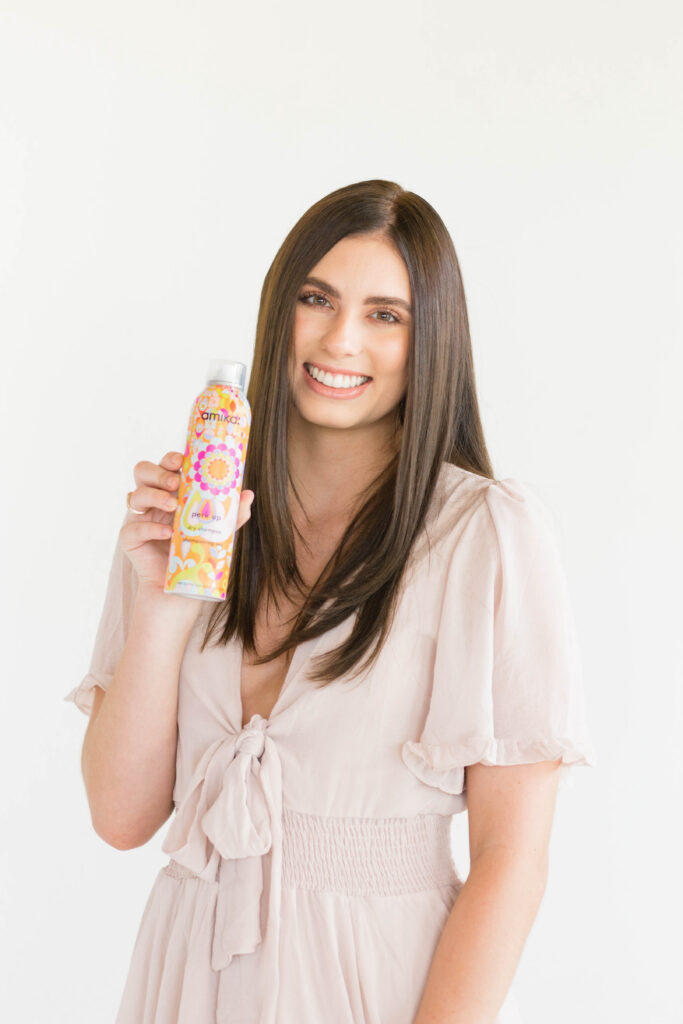 client holding up hair products for brand photography session for salon owner